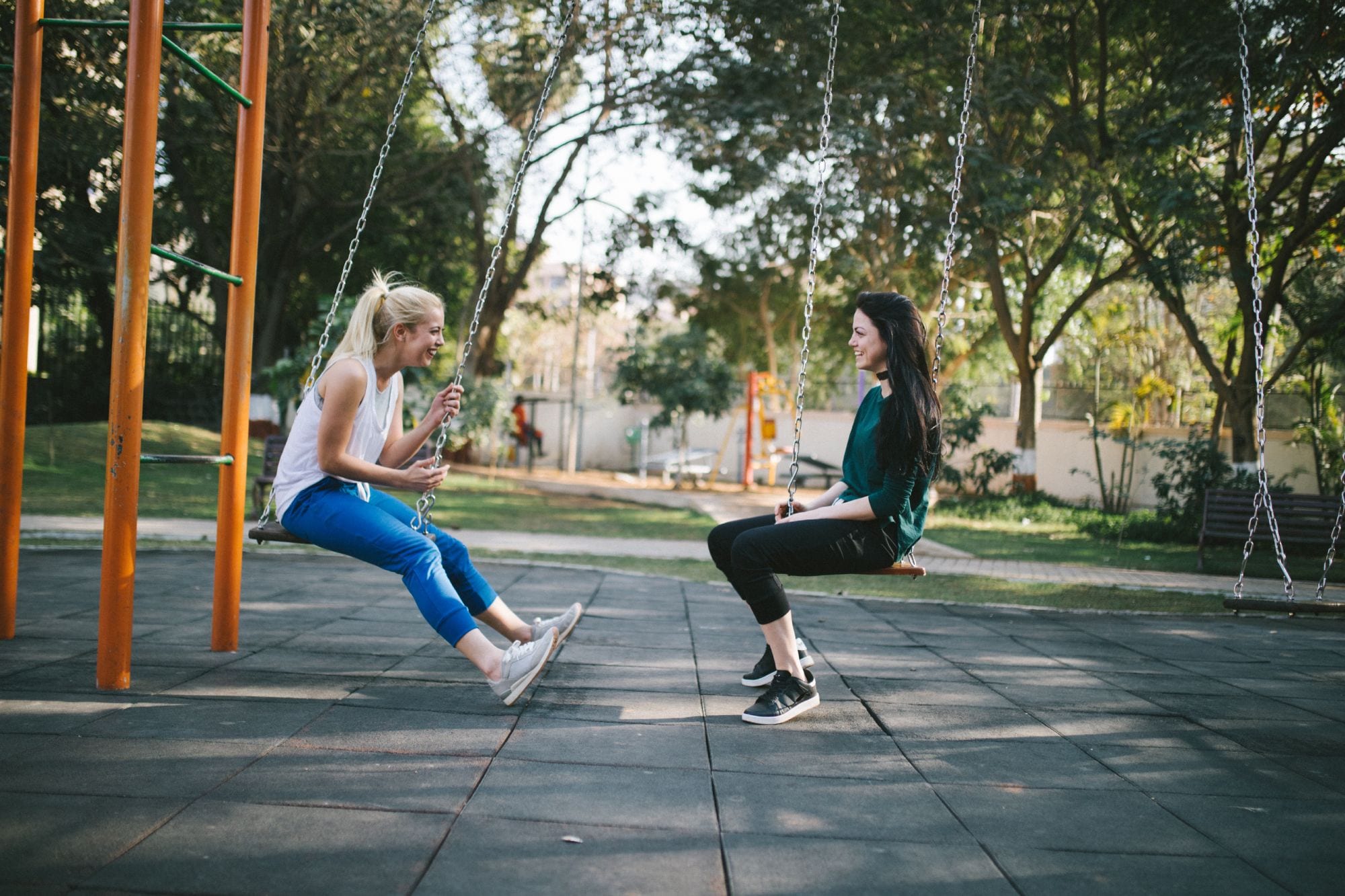 Young mothers talking on swings about child's nut allergy